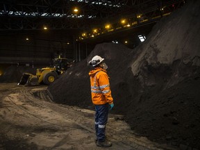 An employee looks at a pile of copper concentrate at a warehouse in Peru.