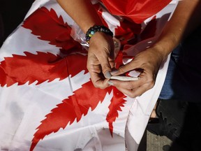 Albertans will soon see pot shops selling cannabis at some festivals and trade shows. The province says it will begin allowing licensed cannabis retailers to operate temporary sales locations at adults-only events come Jan. 31. A cannabis user rolls a joint at a rally in Calgary, Alta., Wednesday, Oct. 17, 2018.