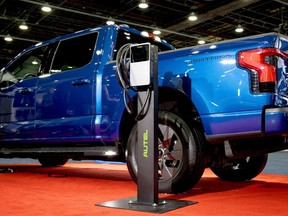 An residential charger beside a Ford electric truck