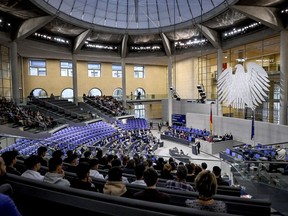 MPs sit in the plenary chamber of the Bundestag, in Berlin, Friday Dec. 15, 2023. The German parliament on Friday approved plans to raise the country's levy on carbon dioxide emissions from fuel by more than previously planned next month, a move that is part of a deal to resolve a budget crisis.