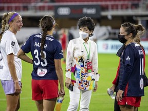 FILE - Washington Spirit co-owner Y. Michelle Kang, third from left, talks to Spirit players after an NWSL soccer match against Racing Louisville FC, Saturday, Oct. 9, 2021, in Washington. Washington Spirit majority owner Michelle Kang has acquired The London City Lionesses soccer team, it was announced Friday, Dec. 15, 2023.