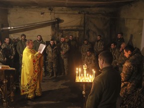 Chaplain Ivan of the Orthodox Church of Ukraine reads a prayer for Ukrainian servicemen of the 72nd mechanized brigade during the sacred liturgy before the upcoming Christmas at the frontline near Vuhledar, Ukraine, Friday, Dec. 15, 2023.