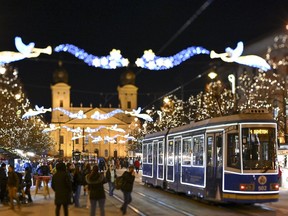 A tram illuminated with Christmas lights commutes in the city centre of Debrecen, northeastern Hungary, Tuesday, Dec. 12, 2023.