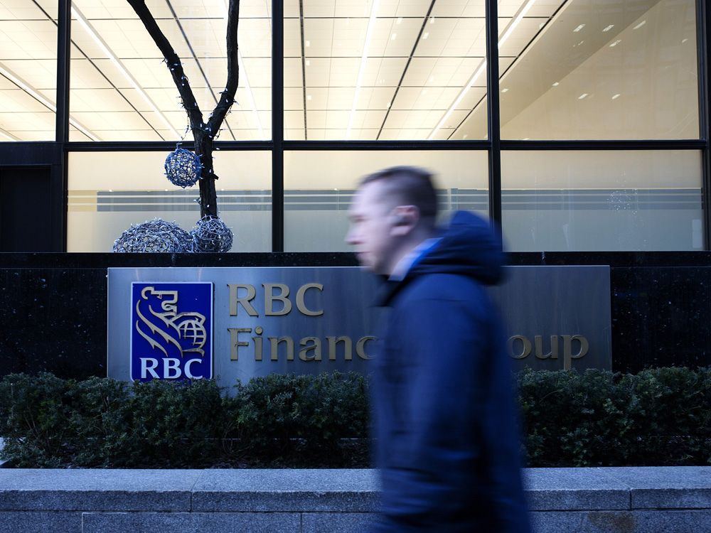 A pedestrian walks past the Royal Bank of Canada in the financial district of Toronto.