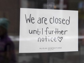 A sign on a shop window indicates the store is closed in Ottawa.