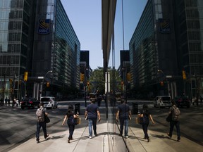 Pedestrians walk near a Royal Bank of Canada building in the financial district of Toronto.