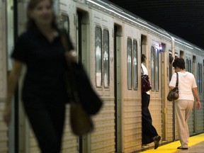 Commuters board a Toronto Transit Commission subway car in Toronto.