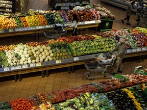 Shoppers walk through produce aisles at a grocery store in Toronto.