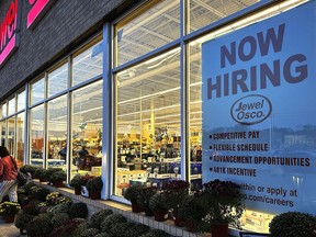 FILE - A hiring sign is displayed at a grocery store, Oct. 5, 2023, in Deerfield, Ill. Most business economists think the U.S. economy could avoid a recession in 2024, even if the job market ends up weakening under the weight of high interest rates, according to a survey released Monday, Dec. 4.
