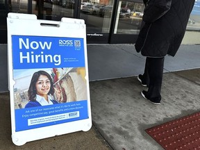 A hiring sign is displayed outside of a retail store in Schaumburg, Ill., Tuesday, Dec.12, 2023. On Thursday, the Labor Department reports on the number of people who applied for unemployment benefits last week.