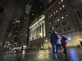 People huddle outside the New York Stock Exchange on Nov. 21, 2023.