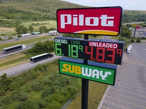 FILE - Trucks and cars drive by a Pilot Travel Center sign displaying fuel prices, June 20, 2022, in Bath, N.Y. Warren Buffett's Berkshire Hathaway will not be allowed to use allegations that billionaire Jimmy Haslam tried to bribe employees at the Pilot truck stop chain to inflate the company's value as Berkshire defends itself in a dispute over the company's accounting practices, a Delaware judge said Wednesday, Dec. 13, 2023.