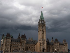 Storm clouds pass by the Peace Tower and Parliament Hill. The federal government recorded a budgetary deficit of $15.1 billion between April and October.