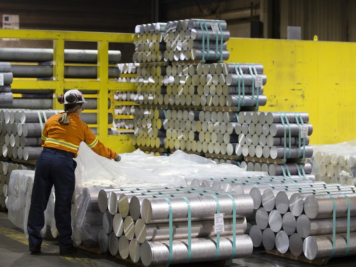  An employee covers a stack of aluminum billets with plastic at a Rio Tinto facility in Quebec.