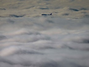 An airplane descends into the fog blanketing the region while on approach to land at Vancouver International Airport, in Richmond, B.C., on Sunday, November 26, 2023. A draft report from a United Nations agency gives Canada a C grade for flight safety and oversight, down from A+.