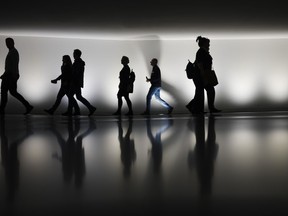 As rent, mortgage payments, grocery bills and other costs rise, more and more Canadians are feeling the weight -- not just on their budgets, but also on their mental wellbeing. People walk through a tunnel connecting an office building in Berlin, Germany, Wednesday, Nov. 22, 2023.