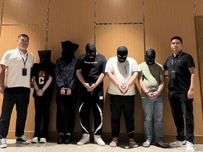 FILE - In this photo released by Xinhua News Agency, Myanmar police hand over five telecom and internet fraud suspects to Chinese police at Yangon International Airport in Yangon, Myanmar, Aug. 26, 2023. Confession videos and national TV broadcasts of the arrests for high-profile suspects are all showcasing a new intensity in China's crackdown against cyberscams.