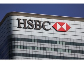 A sign sits on the HSBC Holdings Plc headquarters office building in the Canary Wharf business, financial and shopping district of London, U.K., on Friday, Sept. 18, 2020. After a pause during lockdown, lenders from Citigroup Inc. to HSBC Holdings Plc have restarted cuts, taking gross losses announced this year to a combined 63,785 jobs, according to a Bloomberg analysis of filings. Photographer: Simon Dawson/Bloomberg