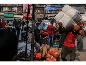 A worker carries goods in the Dharavi district in Mumbai.