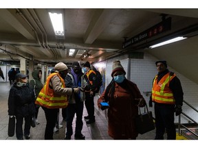 Workers assist commuters at the Times Square subway station in New York on Jan. 5.
