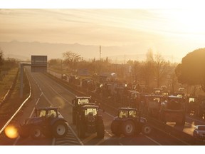 CARBONNE FRANCE - JANUARY 25: Tractors and farm machinery block the A64 highway, south of Toulouse, as farmers continue their protest, demanding government action for their industry on January 25, 2024 in Carbonne, France. French Farmers, the EU's biggest agricultural producer, are blocking roads across France in protest against declining income and over regulation as protests in the European Union's agricultural sector spread.