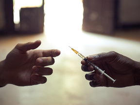 Two people sharing a hypodermic needle