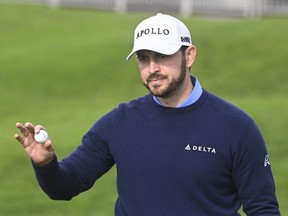 Patrick Cantlay holds up the ball after finishing the first round on the North Course at Torrey Pines, at the Farmers Insurance Open golf tournament Wednesday, Jan. 24, 2024, in San Diego.