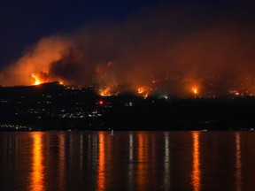 Experts say the escalating risk of severe weather events is one of several factors putting pressure on insurance companies. The McDougall Creek wildfire burns on the mountainside above lakefront homes in West Kelowna, B.C., on Friday, August 18, 2023.