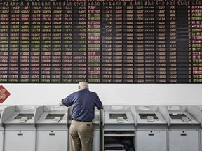 An investor stands at a trading terminal in Shanghai, China