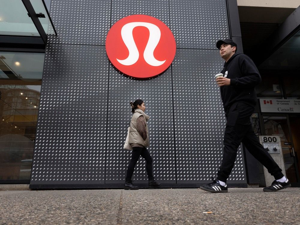 Pedestrians pass a Lululemon store in Vancouver.