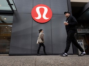 Pedestrians pass a Lululemon store in Vancouver.