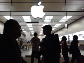 People walk past the Apple Inc. store in the Glendale Galleria shopping mall in California.