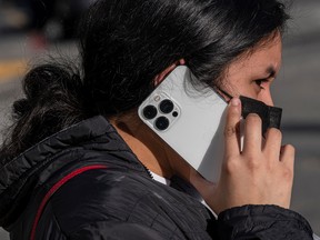A pedestrian uses an Apple iPhone