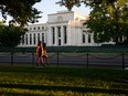 Pedestrians walk past the United States Federal Reserve in Washington, DC.