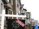 Tanda 'terjual' ditampilkan di depan deretan rumah di lingkungan Belvedere tenggara Calgary, 2023.