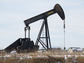 An oil pumper stands in a field along Interstate 25 on Thursday, Nov. 30, 2023, near Erie, Colo. On Friday, the Labor Department releases producer prices data for December.