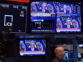 Television screens on the floor of the New York Stock Exchange show the news conference of Federal Reserve Chair Jerome Powell, Wednesday, Jan. 31, 2024. The Fed kept its key rate unchanged at about 5.4%, a 22-year high. In a statement, it signaled a policy shift by dropping previous wording that had said it was still considering further rate hikes.