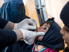 An Afghan refugee child receives a dose of vitamin