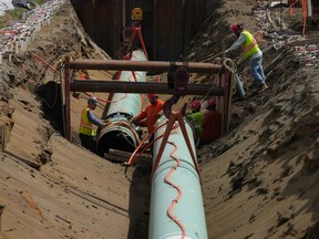 The Trans Mountain pipeline expansion is facing further delay, the company behind the project announced Monday. Workers lay pipe during construction of the Trans Mountain pipeline expansion on farmland, in Abbotsford, B.C., Wednesday, May 3, 2023.