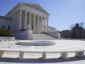 FILE - People stand on the steps of the U.S. Supreme Court, Feb.11, 2022, in Washington. The Supreme Court is taking up challenges by commercial fishermen to a fee requirement that could achieve a long-sought goal of business and conservative interests, limiting a wide range of government regulations. Billions of dollars are potentially at stake.
