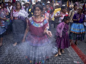 Indigenous women walk to Constitution Plaza to watch the inauguration of Guatemalan President-elect Bernardo Arévalo on a screen outside the National Palace in Guatemala City, Sunday, Jan. 14, 2024.
