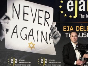 Tesla and SpaceX's CEO Elon Musk holds an artwork received from EJA Chairman Rabbi Menachem Margolin at the European Jewish Association's conference, in Krakow, Poland, Monday, Jan. 22, 2024. Musk visited earlier in the day the site of the Auschwitz-Birkenau Nazi German death camp in Oswiecim, Poland, the private visit apparently took place in response to calls from some Jewish religious leaders for Musk to see with his own eyes the most symbolic site of the horrors of the Holocaust.