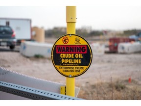 A warning sign near an oil drilling rig in Midland, Texas, US, on Thursday, March 2, 2023. Thousands of miles away from the turmoil on Wall Street, Midland, Texas that ranked No.1 in the US for inflation just over a year ago has since ceded that title – only to lay claim to a different one: the country's pay-raise capital. Photographer: Sergio Flores/Bloomberg