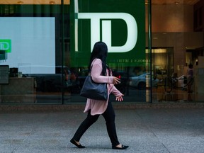 A person walks past a TD Bank sign in the financial district in Toronto on Tuesday, Sept. 20, 2022. According to a new report from TD Economics, recent graduates entering the job market during high unemployment may see a lasting impact on their earnings, especially for younger and inexperienced workers.