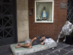 Agustin Catamano, 48, who said he is homeless, sleeps in front of a Catholic institution in Buenos Aires, Argentina, Sunday, Feb. 18, 2024.