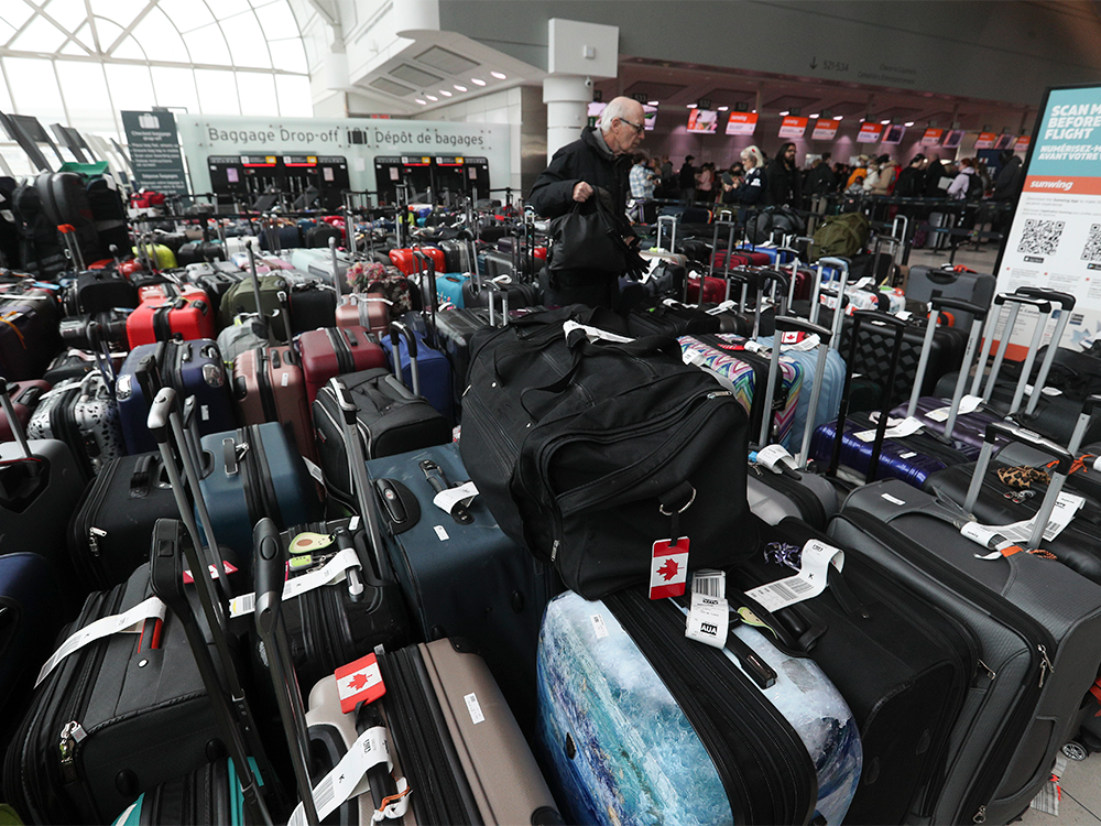 A man searches through baggage at Pearson International airport.