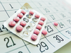 A packet of birth control pills on a calendar