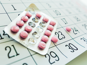 A packet of birth control pills on a calendar