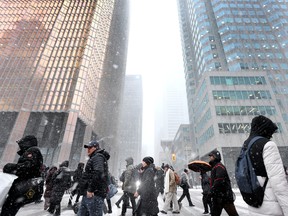 Pedestrians in Toronto's financial district on a snowy day.