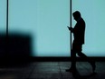 MPs have voted unanimously to summon the chief executives of Canada's three largest telecommunications companies to testify at a federal committee as it studies the accessibility and affordability of wireless and broadband services. A man walks and texts on his smart phone in downtown Toronto, Monday, Oct. 30, 2017.